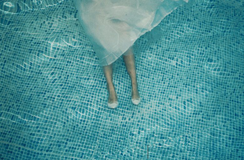 Éva Ostrowska standing on the floor of a mosaic swimming pool, her wedding dress ballooning in the water, solo honeymoon, Palma de Mallorca, 2016